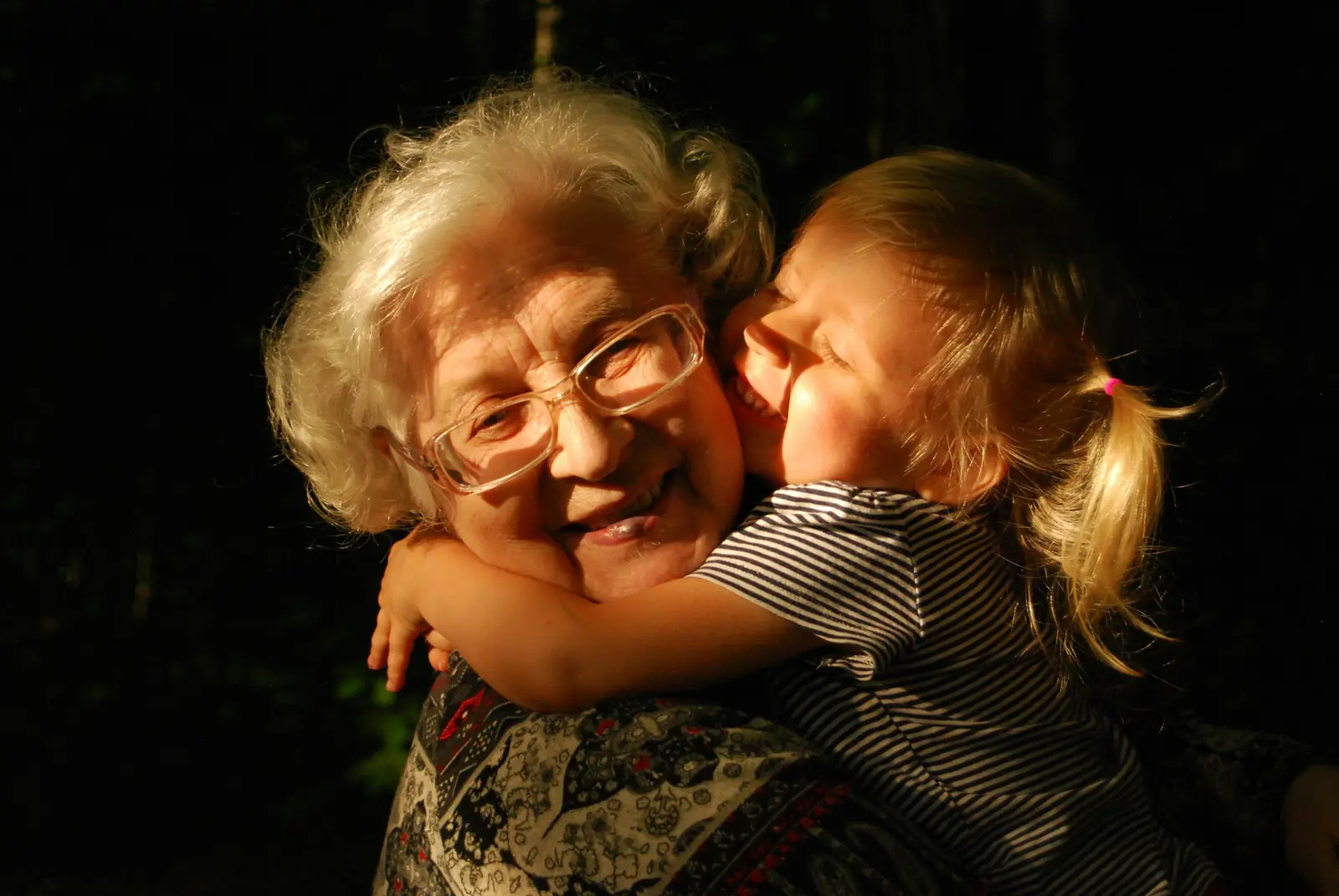 A grandmother and her granddaughter sharing a warm embrace