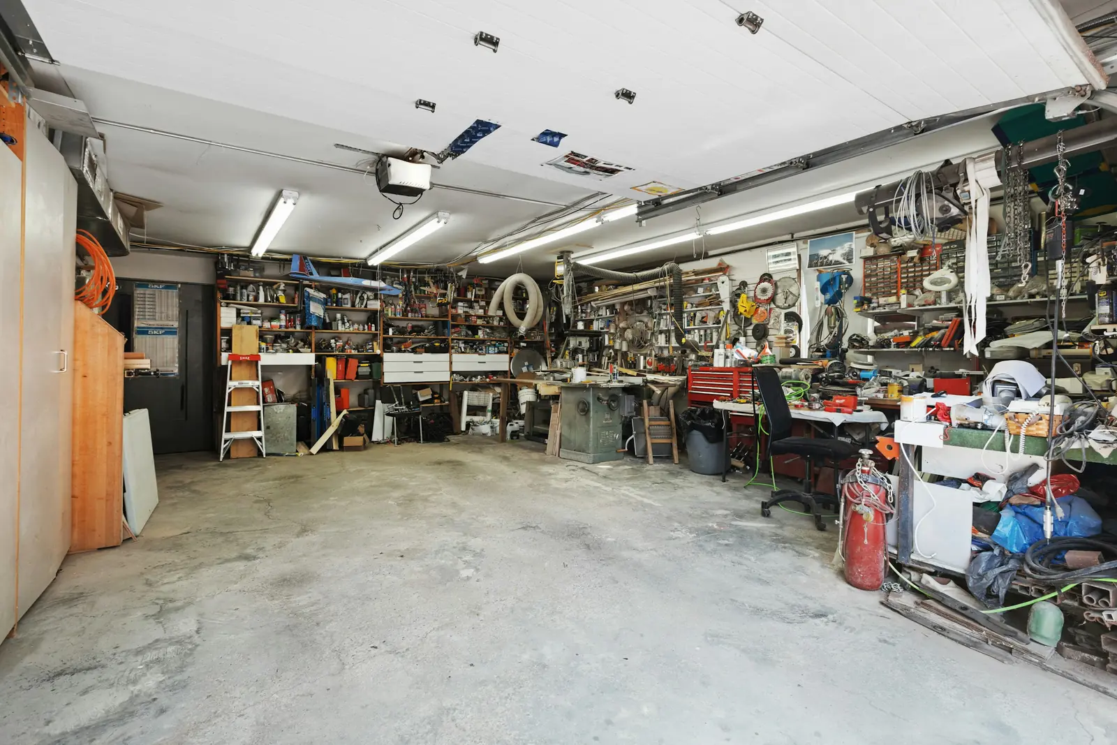 A garage crowded with tools, boxes and equipment
