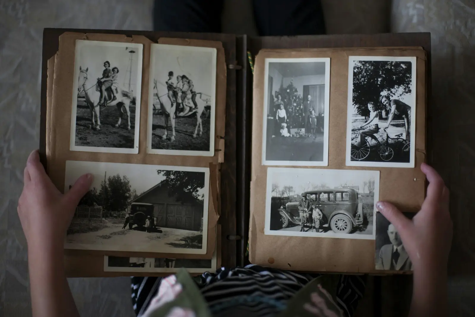 Hands turning the pages of an old family photo album