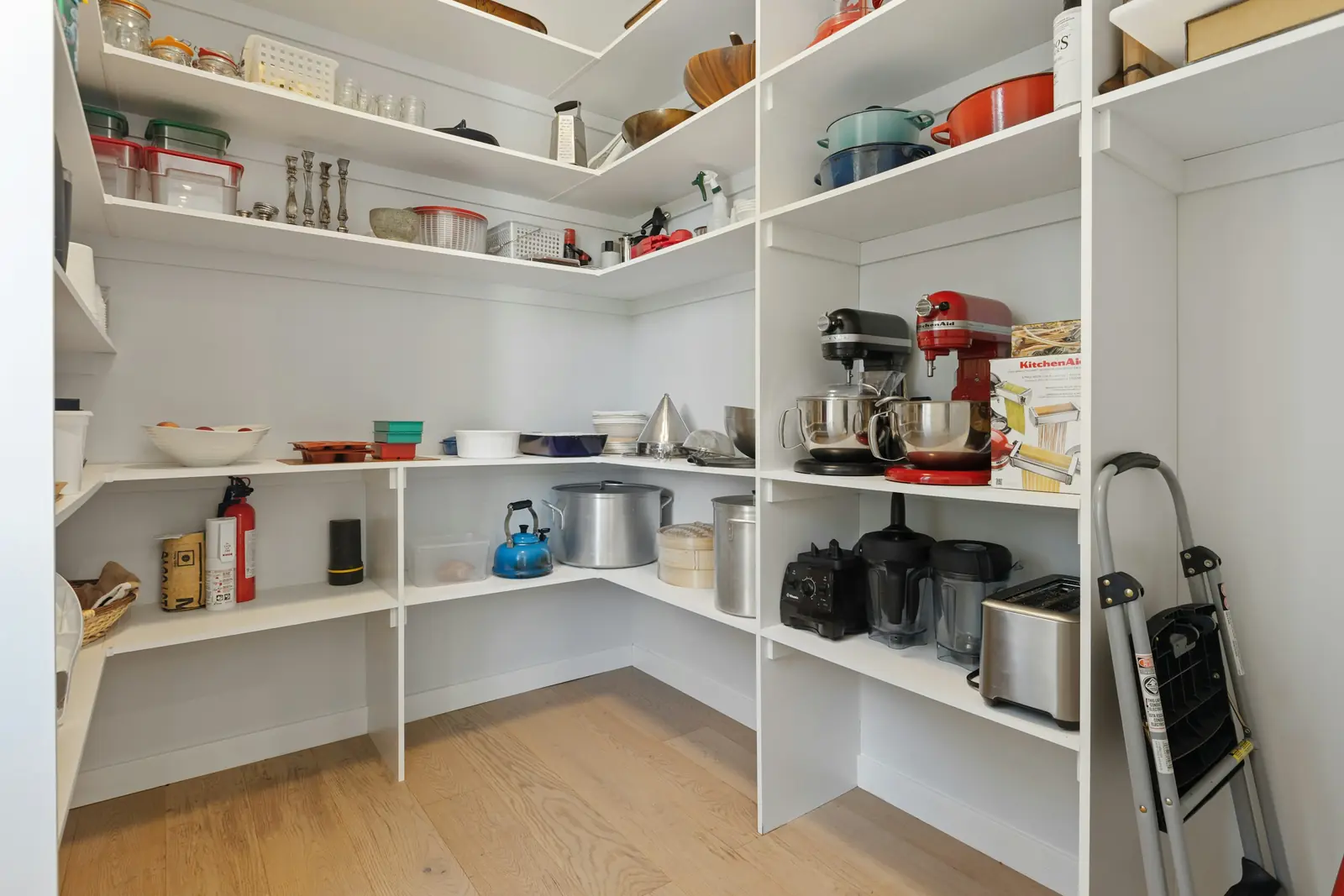 A white walk-in pantry with open shelves